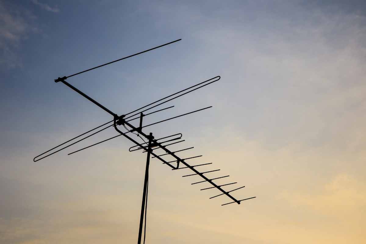 Outdoor Yagi-Uda type antenna silhouetted against a dusky sky with soft golden and blue tones.