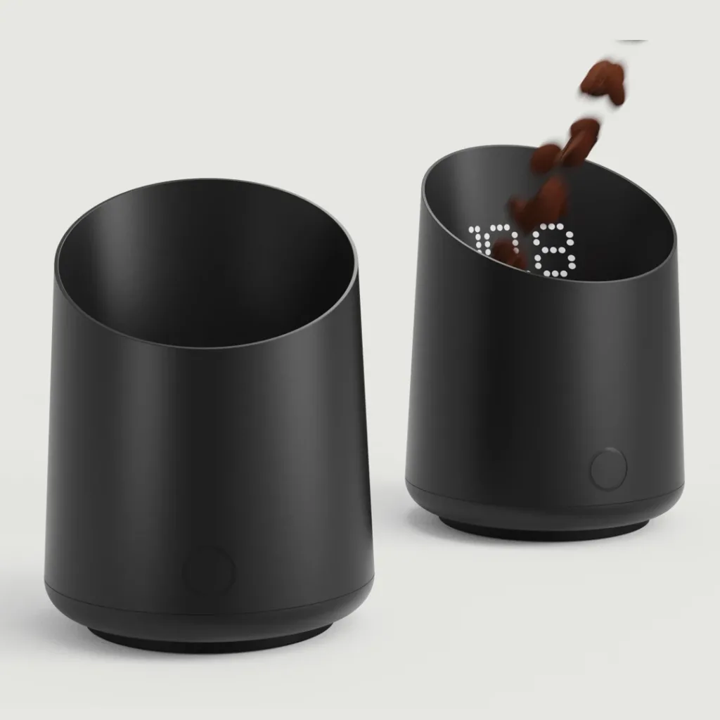 Two Subminimal Subscale Digital Dosing Cups in matte black, shown against a light grey background. The cylindrical, slightly tapered cups feature integrated digital scales and touch-sensitive buttons. The cup on the right displays a white LED weight reading as coffee beans fall into it, while the cup on the left is empty with its display turned off.